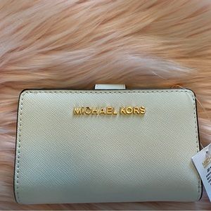 Michael Kors bifold zip coin wallet trimmed in rose gold.
